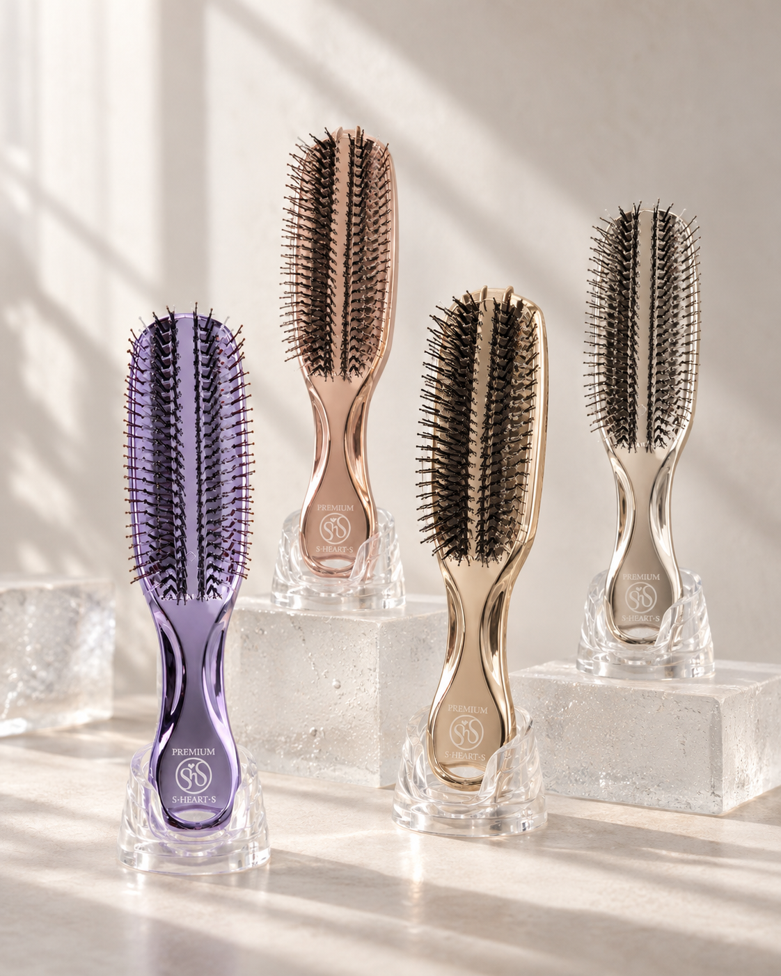 Japanese Cosmetics – zestaw czterech szczotek do włosów S‑HEART‑S na mlecznych szklanych podstawkach w naturalnym świetle dziennym.