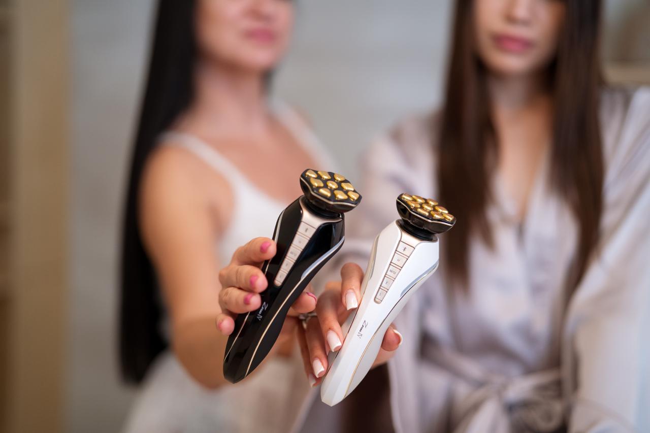 Artistic & Co. Dr. Arrivo Zeus IV facial beauty devices in black and white held by two women — Japanese microcurrent skincare technology